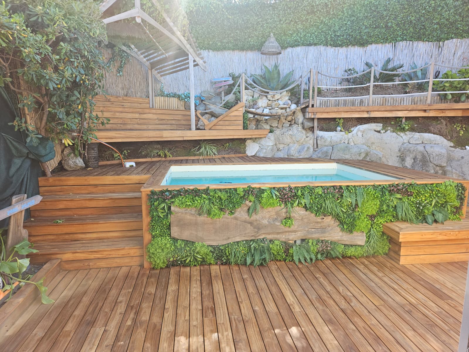 Terrasse en teck avec piscine et mur végétal